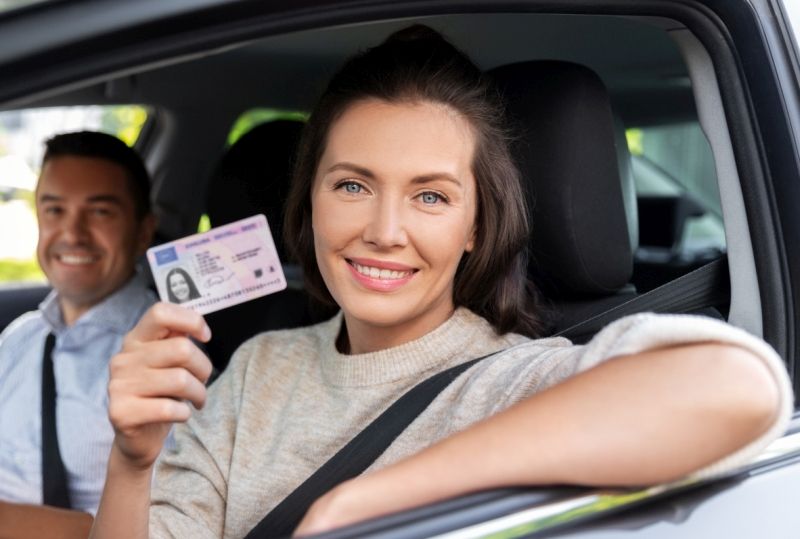 Woman holding a UK driving licence for exchange in Spain